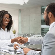 People completing a business transaction by signing a document.