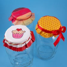 Several lids cover the openings of glass jars.
