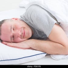 A person sleeping peacefully in a bed.