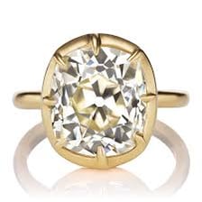 A close-up of a gemstone held in a ring-shaped collet setting.