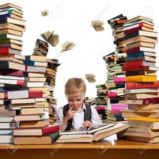 A person reading eagerly beside a stack of books.