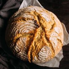 A golden-brown French baguette with a crisp, textured crust.