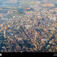 An aerial view of a city spreading outward into surrounding land.