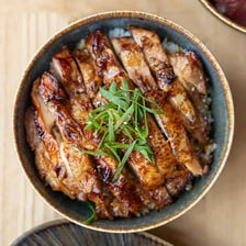 A plate of grilled chicken pieces coated in glossy teriyaki sauce.