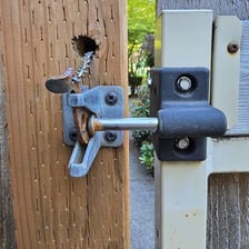 A metal latch securing a garden gate.