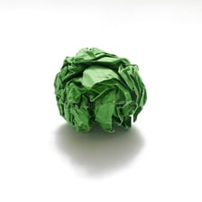 A sheet of paper has been crumpled into a loose ball.