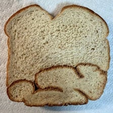 An intact loaf of bread shown as one complete, unbroken piece.