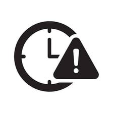 A warning sign beside a clock representing a pressing need for immediate action.