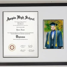 A graduate holding a diploma at a university ceremony.