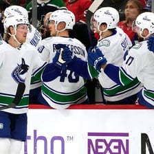 Vancouver Canucks players competing in an ice hockey game.