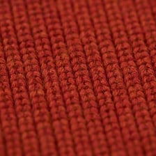 Close-up of a worn sweater covered with small fiber pills.