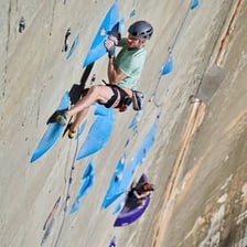 A rock climber ascending a wall toward its top