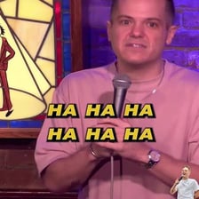 A comedian delivering the final joke line to an amused audience