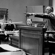People pointing toward a person during a courtroom accusation