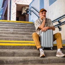 A traveler waiting at a station, illustrating a delay or temporary stay.