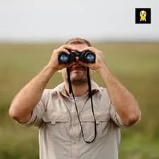 A person surveying a location through binoculars