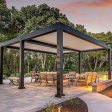A patio furnished in the backyard behind a house.