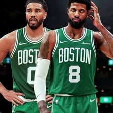 Two basketball forwards competing together on a court