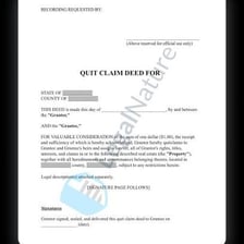 A signed property deed document beside a house key