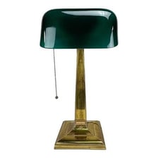 An antique banker’s desk lamp with a green glass shade.