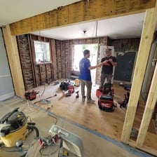 A residential kitchen undergoing renovation with cabinets and construction materials visible