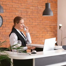A hotel concierge helping a guest at a front desk