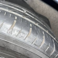 A car tire with a nail causing a puncture