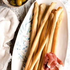A group of thin, crisp Italian breadsticks.