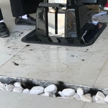 Loose cut hairs scattered across the floor of a barbershop