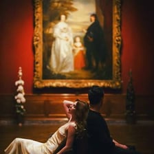 A well-dressed person viewing art in a museum.