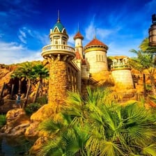 A Disney Fantasyland area with a fairytale castle and themed buildings.