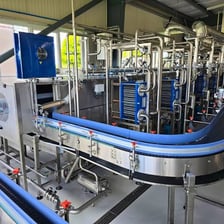 Workers operating machinery in a soft-drink bottling facility