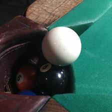 A billiards table with the cue ball in a pocket