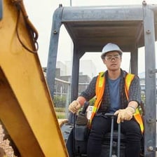 Several workers performing physical labor at a construction site.