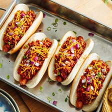A hot dog in a bun topped with chili