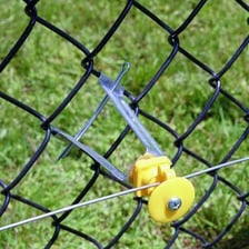 A chain-link fence next to an electrified fence.