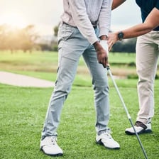 A golf professional instructing a golfer on a course