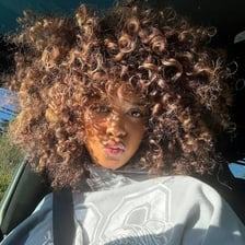 Hair styled into numerous small, tight curls.