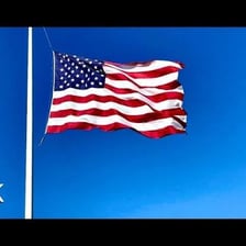 A flag rippling in the wind with a wave-like motion.