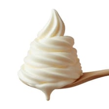A spoon holding a small dollop of whipped cream
