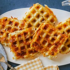A golden waffle being cooked in a waffle iron