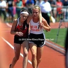 One runner moving ahead of another during a race.