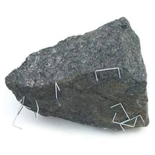 A naturally magnetized lodestone attracting iron filings.