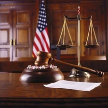 An upright judge beside the scales of justice in a courtroom