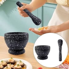 A pestle resting beside a mortar bowl.