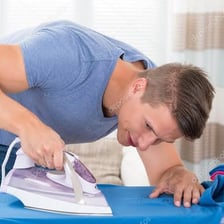 A person pressing a garment with a household iron