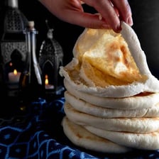 A pita bread opened to reveal its hollow pocket.