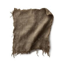 A piece of cloth with heavily torn and frayed edges