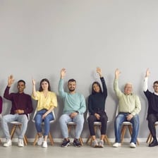 A group of people raising their hands in agreement during a vote.