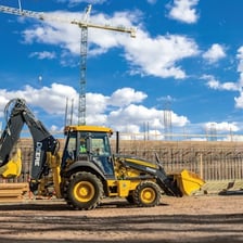 Backhoe excavator digging earth at a construction site.